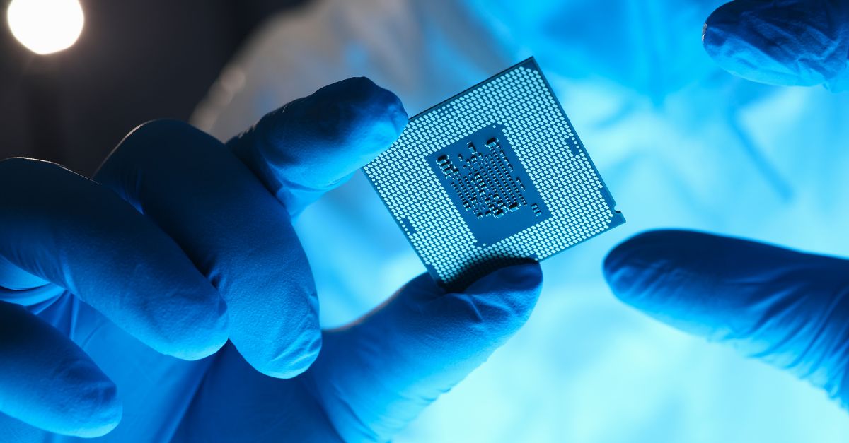 obrazek przedstawiający dłonie naukowca w niebieskich rękawiczkach trzymające urządzenie mikroelektroniczne